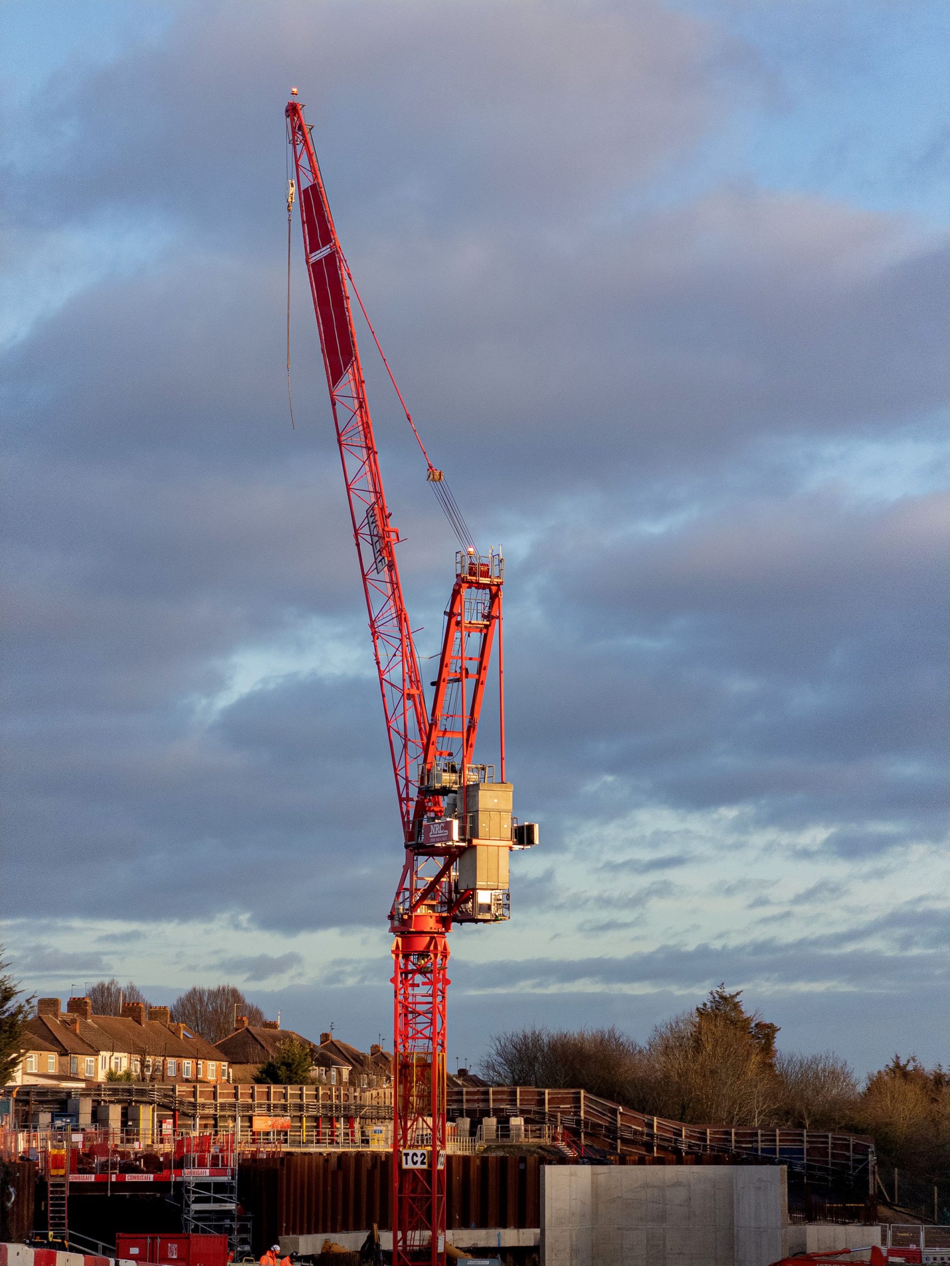 Red tower crane over a London building site at sunset